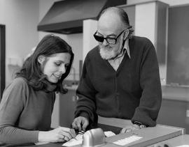 Photograph of Hero Kielman working with a student as she chooses gemstones for a project