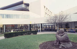 Photograph of mother and child sculpture on the lawn in front of the entrance to "E" bu...
