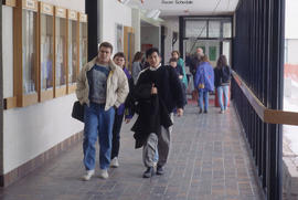 Photograph of students walking the main hallway in front of D building