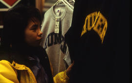 A photograph of a student looking at Humber branded sweaters