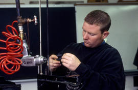 Photograph of student working with a small engine