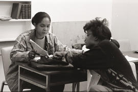 Photograph of two persons looking at a document