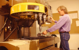 Photograph of a Student Using a Computerized Metal Drill Press.