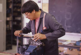Photograph of a student working in a small engines repair lab