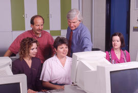 Photograph of five staff members at a computer workstation