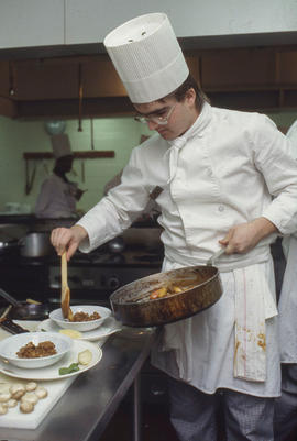 Photograph of a student preparing food to serve in the Humber Room