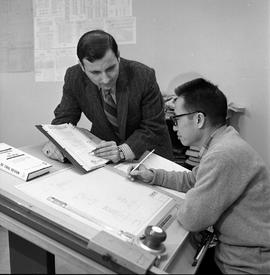 Photograph of Mike Sava assisting a student with completing a drafting assignment