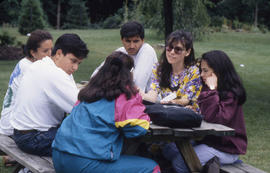 Photograph of Students Sitting on a Picnic Bench in the Arboretum
