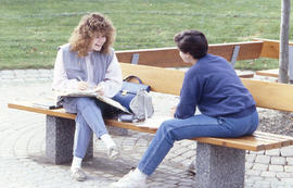 Photograph of students talking at a bench near the Arboretum entry way