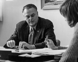 Photograph of Arthur King Meeting With a Student in His Office