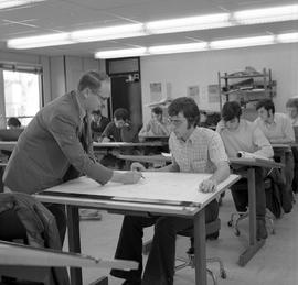 Photograph of Fred Irving assiting a student in in architectural drafting