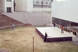 KX building with people on an outdoor stage : [photograph]