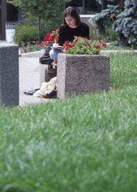 Photograph of a student sitting on a bench studying