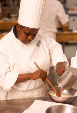 Photograph of a Culinary program student mixing ingredients