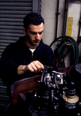 Photograph of student working on a small engine