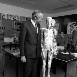 Photograph of a visitor standing next to a life size human model
