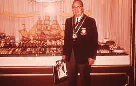 Igor Sokor, Head of Culinary Programs, wearing a medal in front of a display of deserts : [photog...