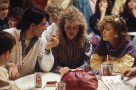 Photograph of students in conversation sitting at a table in CAPS