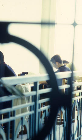 A photograph of students viewed through a railing