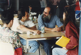 Photograph of John Steckley seated with students in the Lakeshore cafeteria