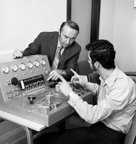 Photograph of Joe Pusztai helping a student at an instrumentation and control bench