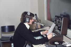 IMC staff member in radio booth : [photograph]
