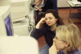 A photograph of a student with closed eyes at a computer
