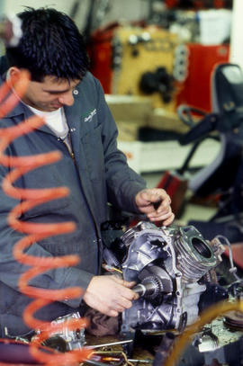 Photograph of a student working on a small engine