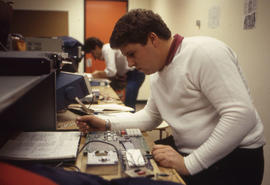 Photograph of a student working at an electronics workbench