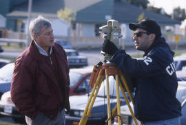 Photograph of Civil Engineering instructor Frank Mee directing student using survey equipment