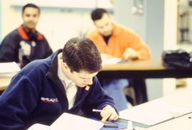 A photograph of a student working on a calculator