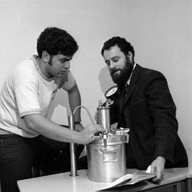 Photograph of an instructor using a pressure vessel with a student