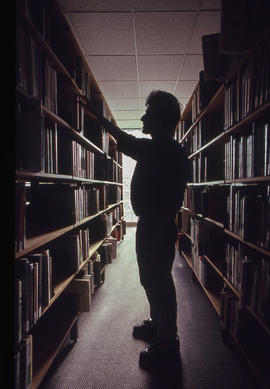 Photograph of a person browsing books in the library