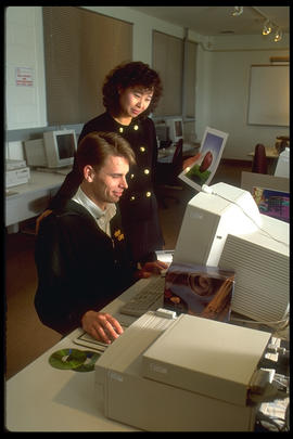 Photograph of a technician and Betty Tam-Cheung at the computer