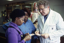 Photograph of faculty member Henry Ruschin working with two students in the Anatomy lab