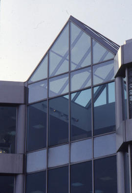 Photograph of the glass peak of NX building viewed against a clear sky