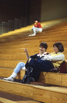 Photograph of students in conversation on the bleachers