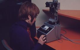 IMC staff member working with film slides : [photograph]