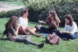 Photograph of a Group of Girls Sitting on The Grass Talking