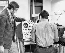 Photograph of Joe Enekes Assisting a Student who is using an Oscilloscope