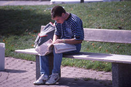 Photograph of a student reading the daily newspaper