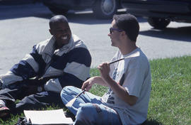 Photograph of two students on the lawn in conversation