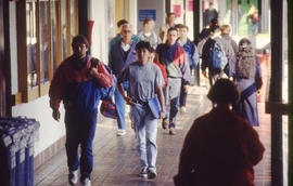 Photograph of students walking along the main hallway in building "D" near the Registra...