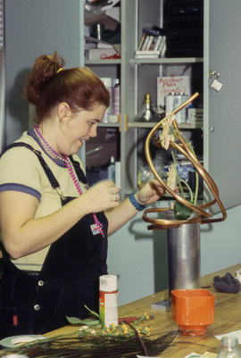 A photograph of a Retail Floriculture student preparing a floral arrangement