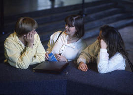 Photograph of three women conversing with each other on the concourse