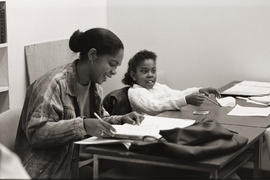 Photograph of an adult person and child seated