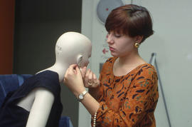 Photograph of a Retail Co-op student dressing a mannequin for a window display
