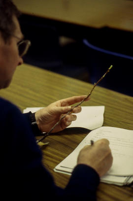 A photograph of a Floriculture student examining a twig