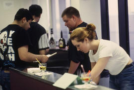 A photograph of Bartending students preparing drinks