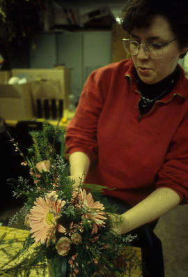 A photograph of a Retail Floriculture student preparing a floral arrangement